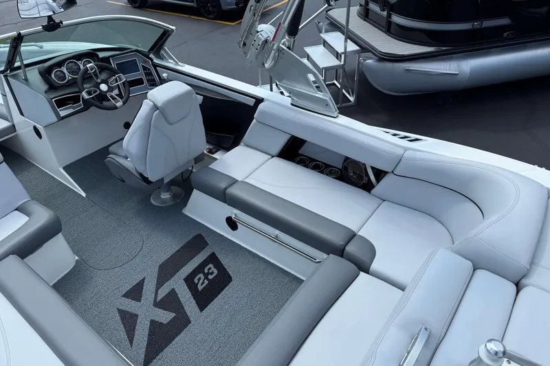 Slide: The Image of 2020 MasterCraft XT23 boat interior with sleek seating and modern dashboard. - 6