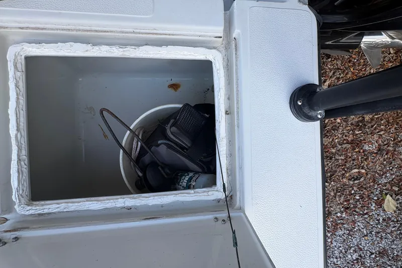 Slide: The Image of Open storage compartment on 1994 Hewes Redfisher 18 boat with fishing gear inside. - 11
