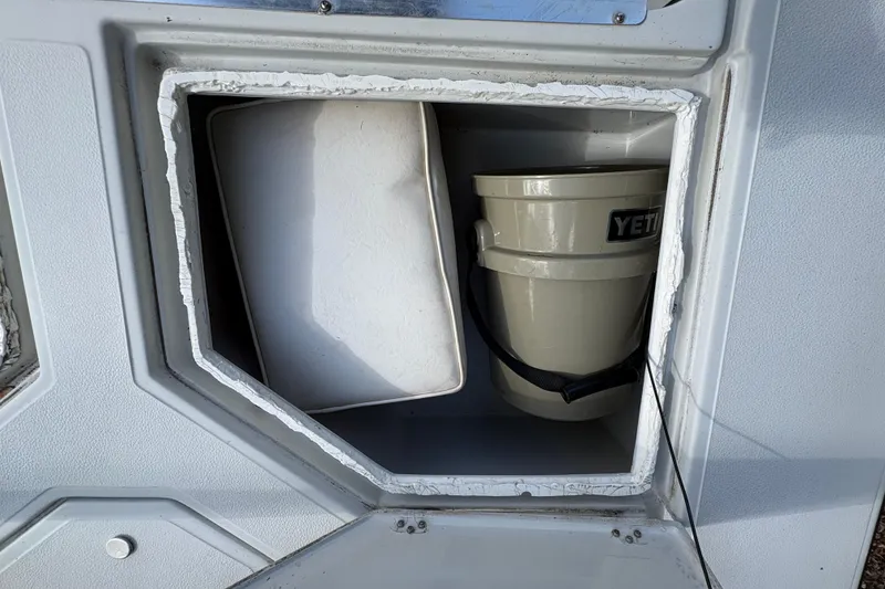 Slide: The Image of Storage compartment on a 1994 Hewes Redfisher 18 boat with a YETI bucket. - 13