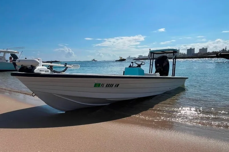 Slide: The Image of 1994 Hewes Redfisher 18 boat on sandy beach with clear blue water background. - 4
