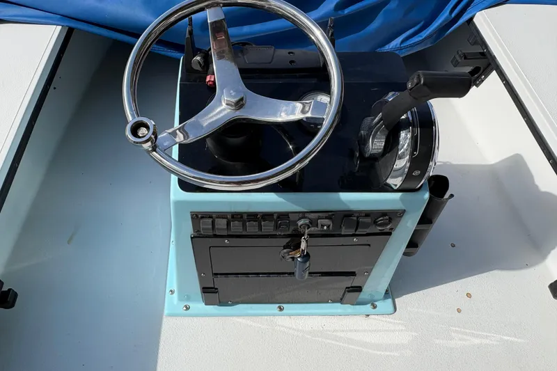 Slide: The Image of Steering console of a 1994 Hewes Redfisher 18 boat with controls and key. - 6