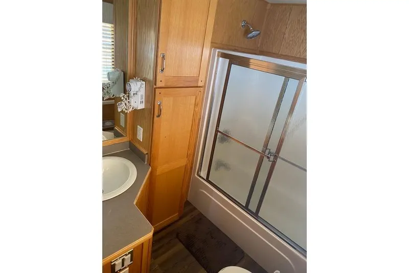 Slide: The Image of Bathroom interior of 2005 Sumerset Starchaser, featuring shower and wooden cabinetry. - 16