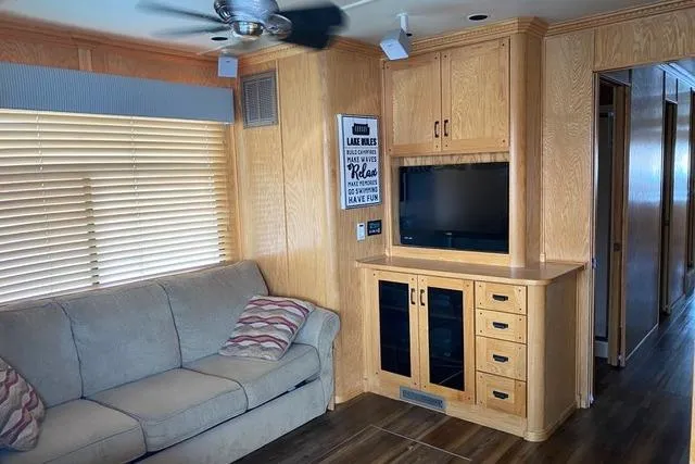 Slide: The Image of Cozy living area in 2005 Sumerset Starchaser houseboat with sofa, TV, and wooden cabinetry. - 17