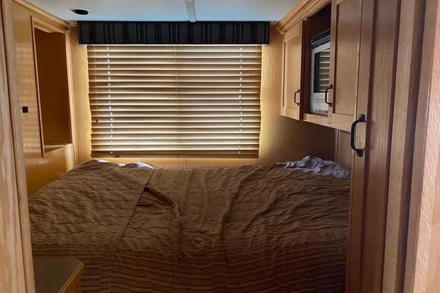 Slide: The Image of Cozy bedroom interior of 2005 Sumerset Starchaser houseboat with wooden cabinetry and blinds. - 5