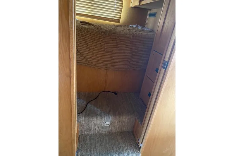 Slide: The Image of Cozy interior of 2005 Sumerset Starchaser, featuring wooden cabinetry and carpeted flooring. - 6