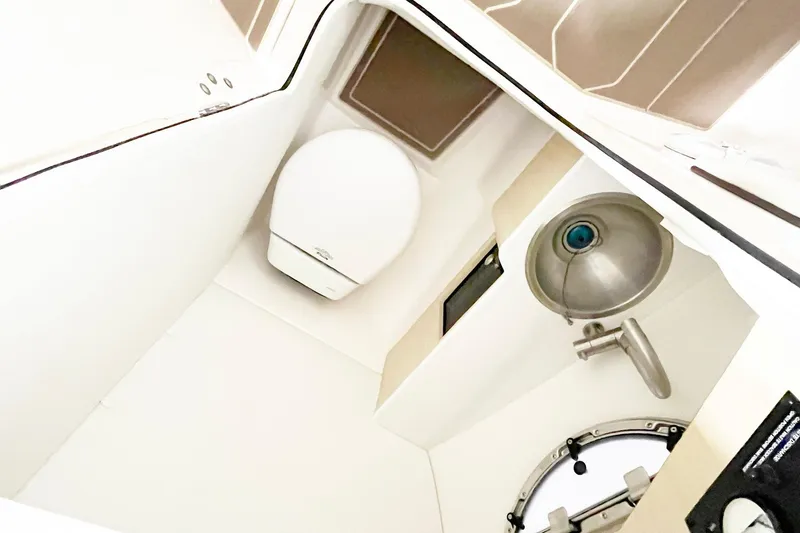 Slide: The Image of 2025 Regal LX6 boat interior bathroom with toilet and sink. - 11