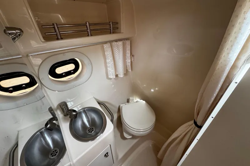 Slide: The Image of 2016 Sea Ray Sundancer 260 bathroom with dual sinks and compact toilet. - 11