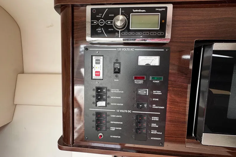 Slide: The Image of Control panel of a 2016 Sea Ray Sundancer 260 boat with various switches and a stereo system. - 12