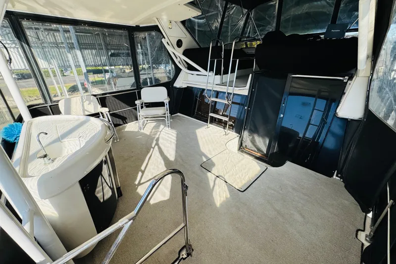 Slide: The Image of 1995 Bayliner 4587 Motoryacht interior with seating, sink, and ladder in a sunlit cabin. - 11