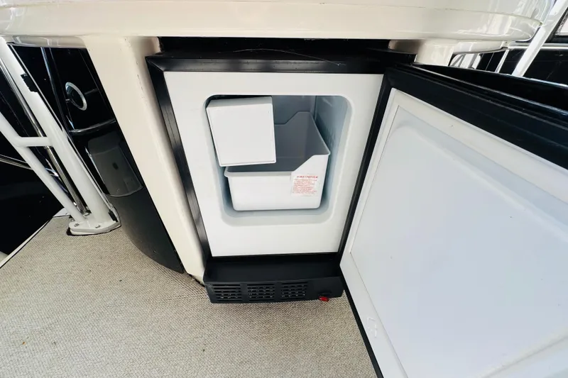 Slide: The Image of Open mini fridge on 1995 Bayliner 4587 Motoryacht, showcasing interior storage space. - 17
