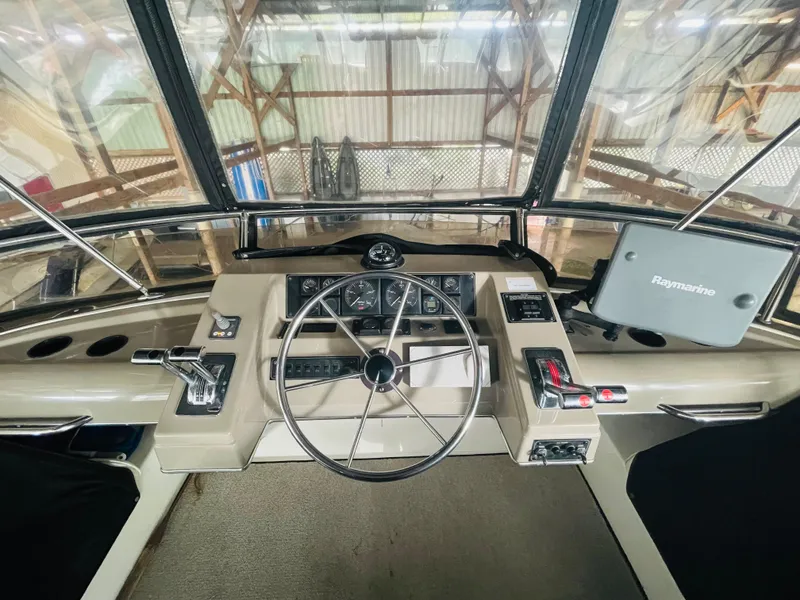 Slide: The Image of 1995 Bayliner 4587 Motoryacht helm with steering wheel and Raymarine navigation system. - 19