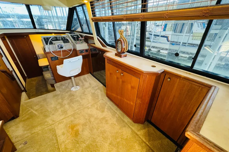 Slide: The Image of Interior of 1995 Bayliner 4587 Motoryacht with helm, wooden cabinetry, and large windows. - 27
