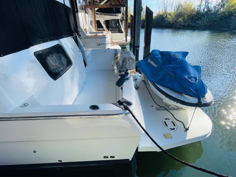 Slide: The Image of 1995 Bayliner 4587 Motoryacht docked with a jet ski on the swim platform. - 3