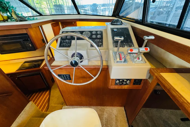 Slide: The Image of 1995 Bayliner 4587 Motoryacht helm with steering wheel, controls, and navigation instruments. - 32
