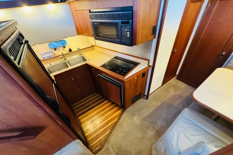 Slide: The Image of Compact kitchen in a 1995 Bayliner 4587 Motoryacht with stove, microwave, and double sink. - 33