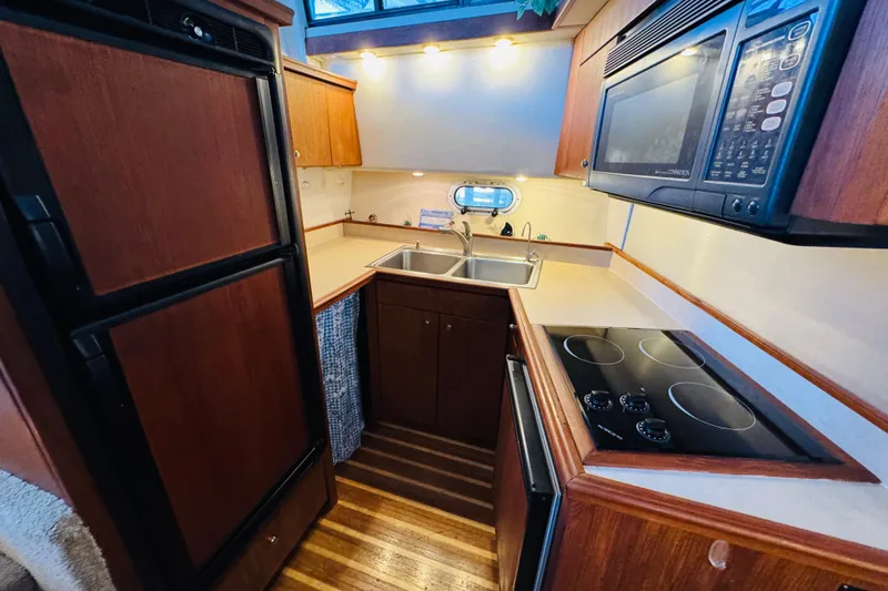 Slide: The Image of 1995 Bayliner 4587 Motoryacht kitchen with stove, microwave, and double sink. - 34