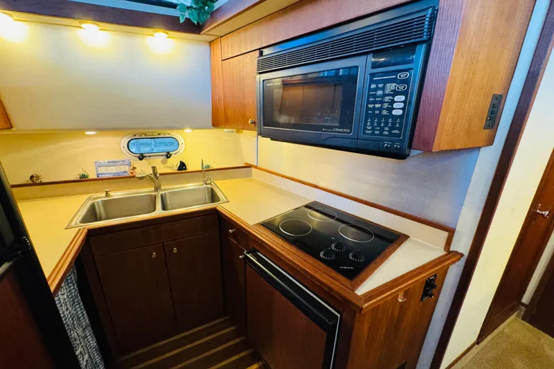 Slide: The Image of 1995 Bayliner 4587 Motoryacht kitchen with microwave, stovetop, and double sink. - 35
