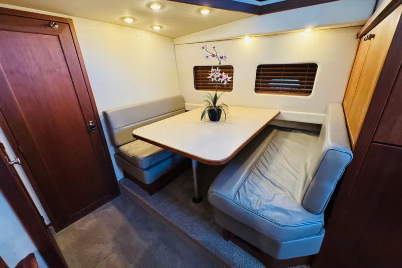 Slide: The Image of Cozy dining area in 1995 Bayliner 4587 Motoryacht with cushioned seating and table. - 36