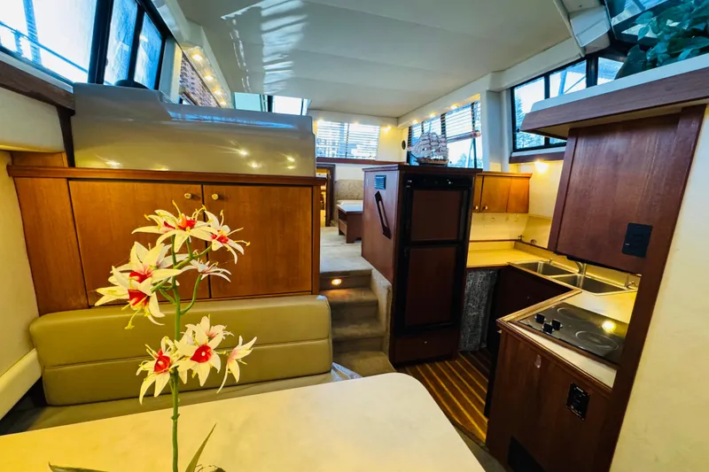 Slide: The Image of Interior of 1995 Bayliner 4587 Motoryacht with kitchen, dining area, and floral centerpiece. - 38