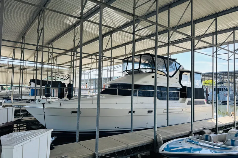Slide: The Image of 1995 Bayliner 4587 Motoryacht docked in a covered marina, side view. - 4