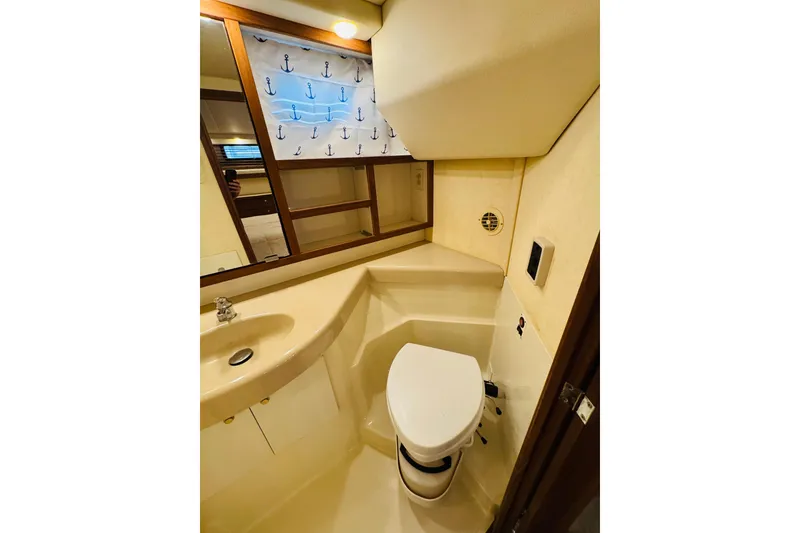 Slide: The Image of Bathroom interior of 1995 Bayliner 4587 Motoryacht with sink, toilet, and anchor-themed curtain. - 42