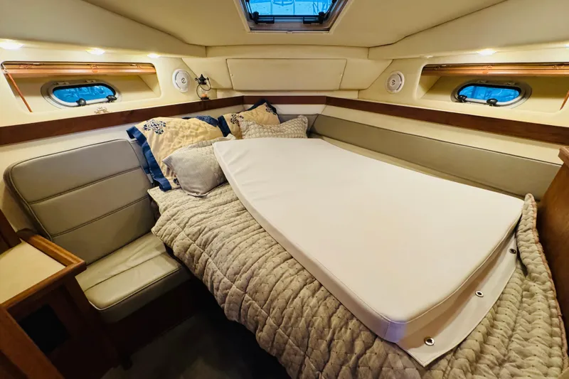 Slide: The Image of Cozy cabin interior of 1995 Bayliner 4587 Motoryacht with plush bedding and porthole windows. - 44