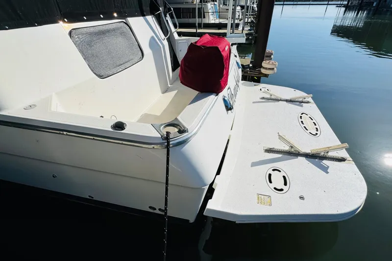 Slide: The Image of 1995 Bayliner 4587 Motoryacht docked, featuring a spacious swim platform and sleek design. - 9
