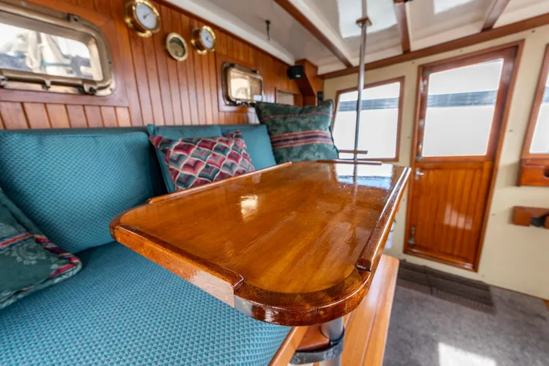 Slide: The Image of Interior of 1986 Kadey-Krogen 42 yacht with wooden table and blue seating. - 12