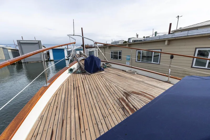 Slide: The Image of 1986 Kadey-Krogen 42 yacht deck with wooden finish, docked near houseboats. - 27