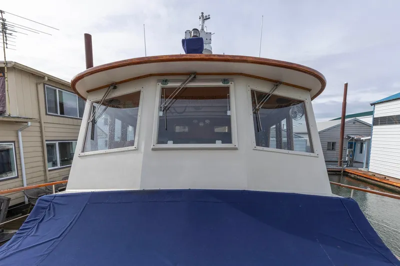 Slide: The Image of 1986 Kadey-Krogen 42 boat docked, featuring a covered deck and large windows. - 28