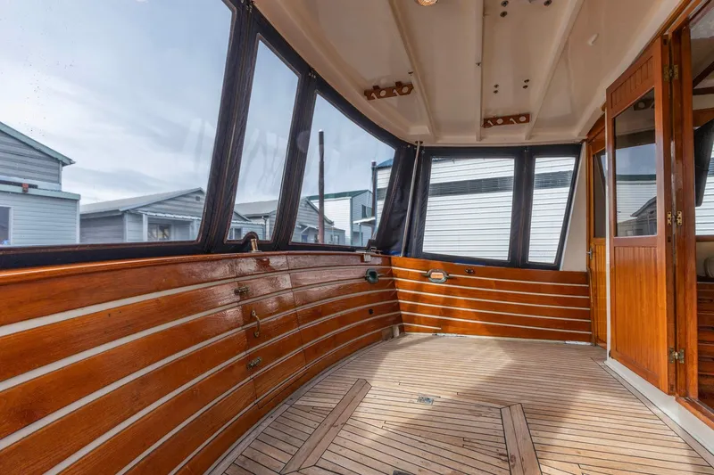 Slide: The Image of Enclosed deck of 1986 Kadey-Krogen 42 yacht with wooden paneling and large windows. - 30