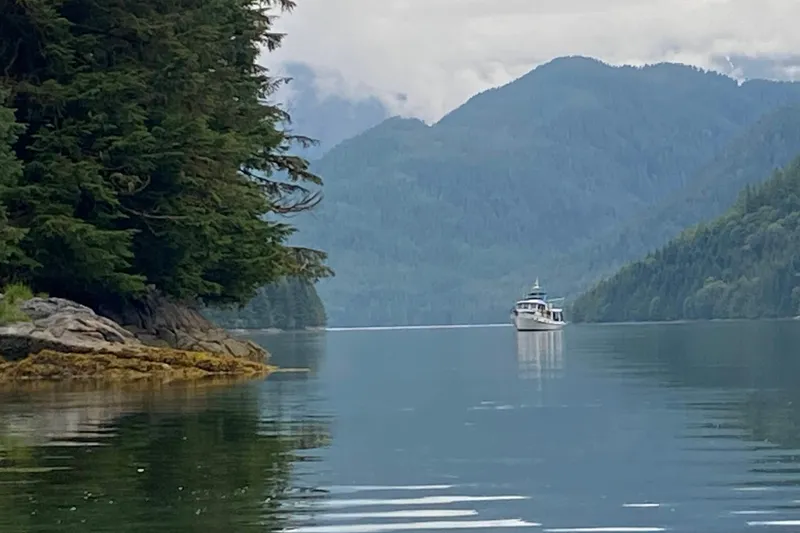 Slide: The Image of 1986 Kadey-Krogen 42 yacht cruising in serene, forested mountain landscape. - 51