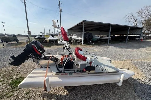 Slide: The Image of 2002 CRAIG Cat boat with Mercury outboard motor in a gravel lot. - 3