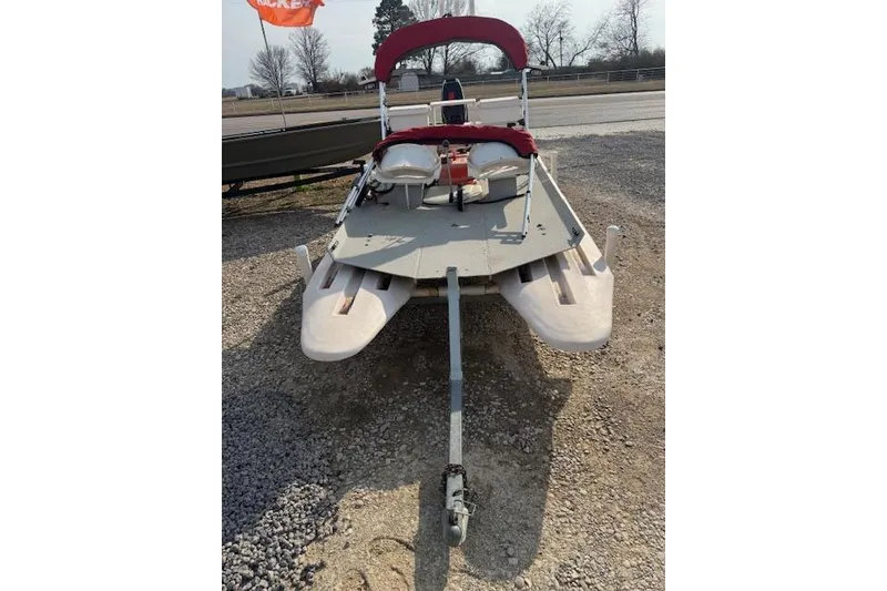 Slide: The Image of 2002 CRAIG Cat boat with red canopy on gravel lot. - 4