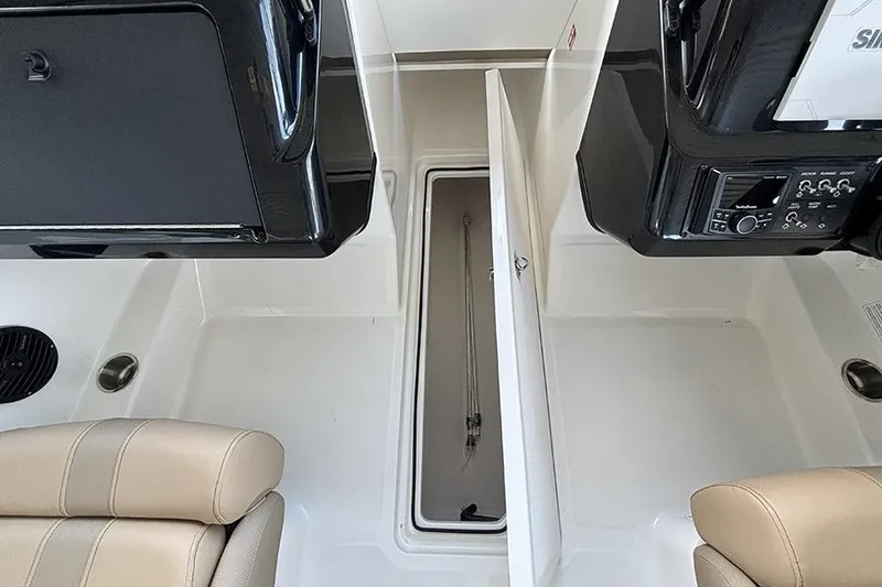 Slide: The Image of 2026 Bayliner V20i boat interior with seating and steering wheel, parked outdoors. - 7