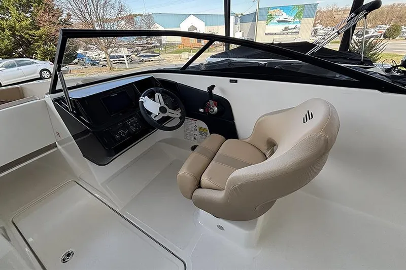 Slide: The Image of 2026 Bayliner V20i boat interior with beige seating, docked among other boats. - 9