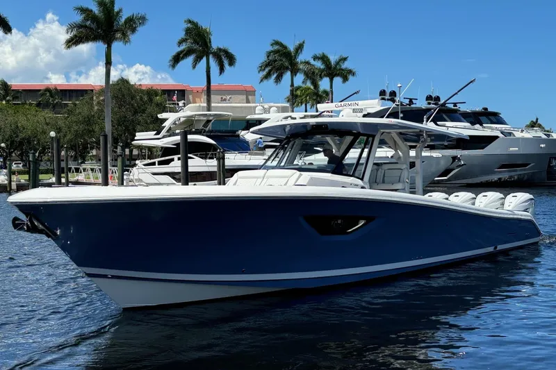 The Image of 2023 Pursuit S 428 Sport boat docked with palm trees in background. - 0