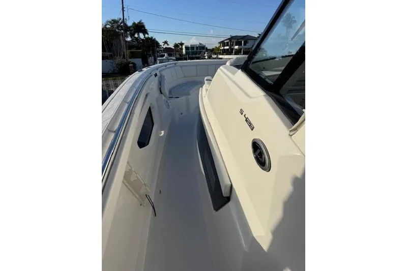 Slide: The Image of 2023 Pursuit S 428 Sport boat deck, sleek design, coastal background. - 12