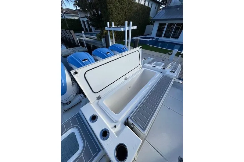 Slide: The Image of 2023 Pursuit S 428 Sport boat with open storage compartment and blue engines. - 16