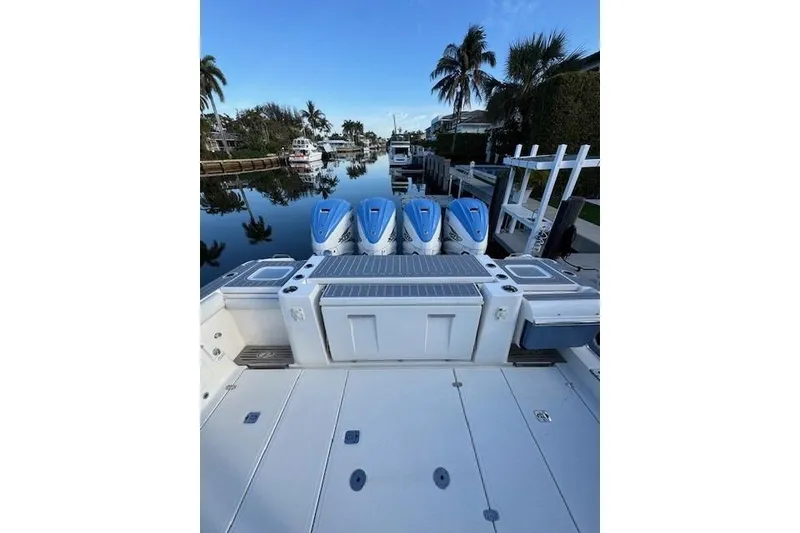 Slide: The Image of 2023 Pursuit S 428 Sport boat with four engines docked by a canal. - 19