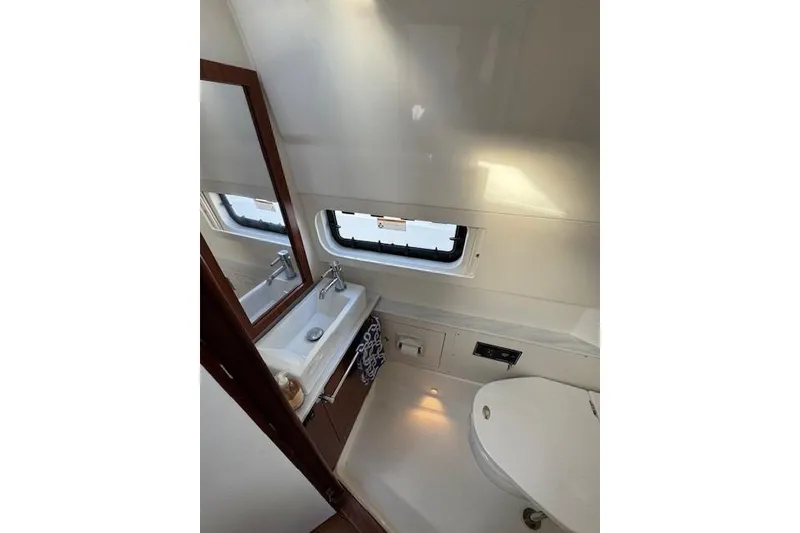 Slide: The Image of 2023 Pursuit S 428 Sport boat bathroom with sink, mirror, and window. - 20