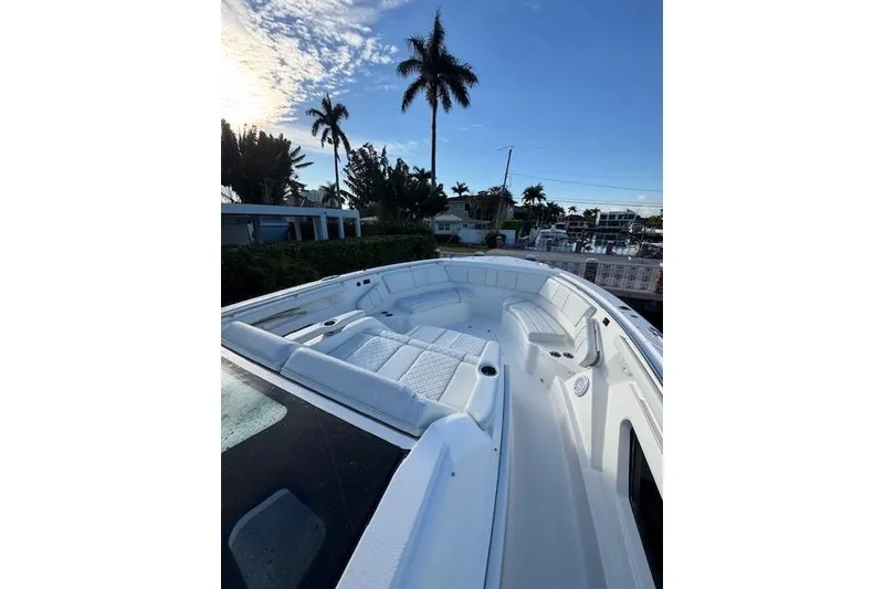 Slide: The Image of 2023 Pursuit S 428 Sport boat deck with seating, under a clear blue sky. - 7