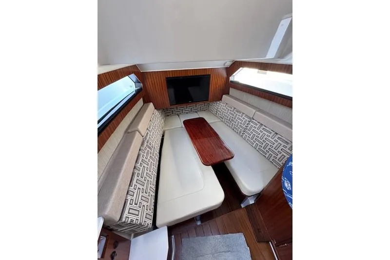 Slide: The Image of 2023 Pursuit S 428 Sport cabin interior with elegant seating and wooden table. - 9