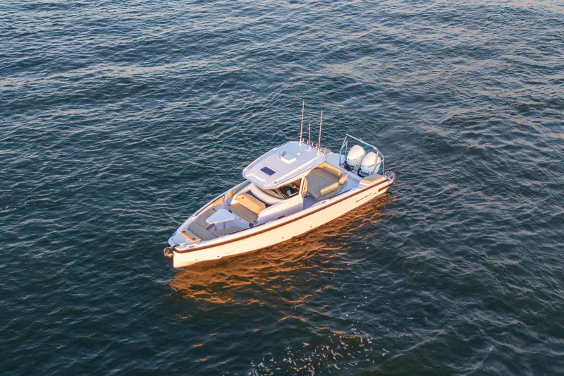 Slide: The Image of 2026 Axopar 29 CCX boat cruising on calm waters at sunset. - 19