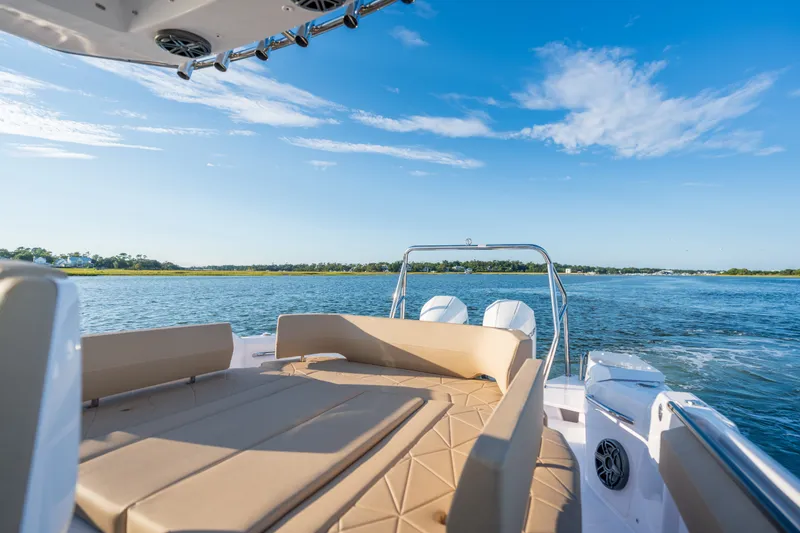 Slide: The Image of 2026 Axopar 29 CCX boat on serene water with clear blue sky. - 24