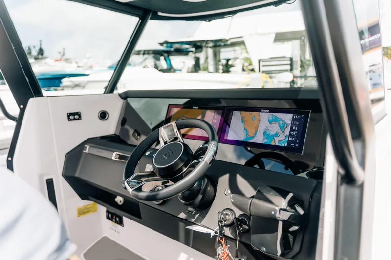 Slide: The Image of 2026 Axopar 29 CCX boat cockpit with modern navigation system and steering wheel. - 13