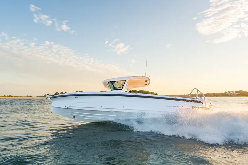 Slide: The Image of 2026 Axopar 29 CCX boat cruising on water at sunset. - 21