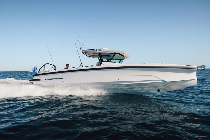 Slide: The Image of 2026 Axopar 29 CCX boat cruising on open water, side view. - 26