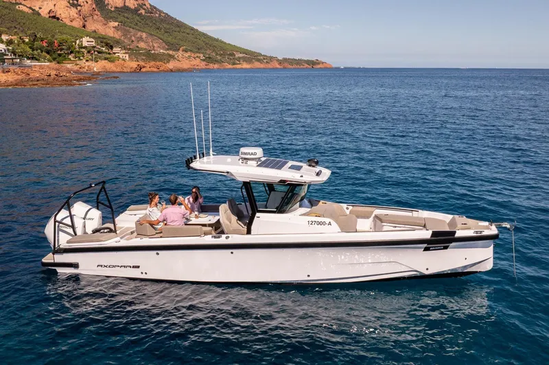 Slide: The Image of 2026 Axopar 29 CCX boat cruising on clear blue water with passengers enjoying the ride. - 27