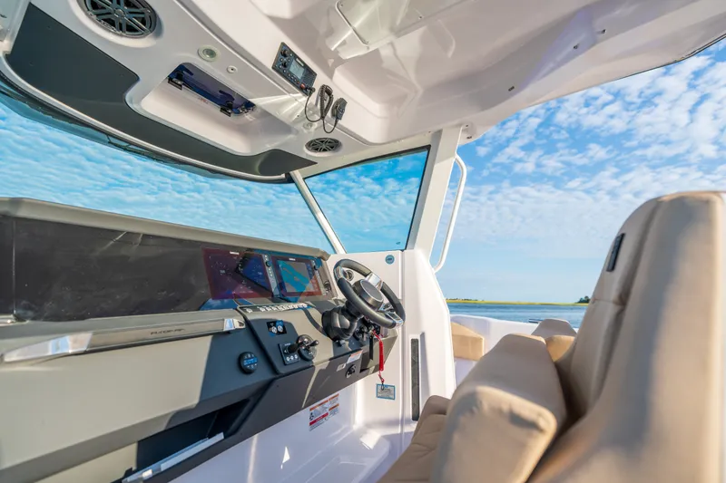 Slide: The Image of Interior view of 2026 Axopar 29 CCX boat cockpit with modern controls and seating. - 34